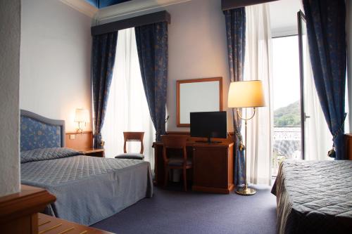 a hotel room with two beds and a television at Hotel Due Palme in Mergozzo