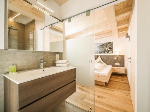 ein Badezimmer mit einem Waschbecken und ein Schlafzimmer im Hintergrund in der Unterkunft Leitnerhof in Ramsau im Zillertal