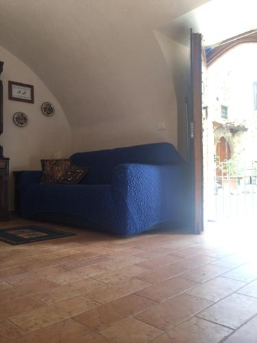 a living room with a blue couch in the corner at Casa a Santo Stefano di Sessanio in Santo Stefano di Sessanio