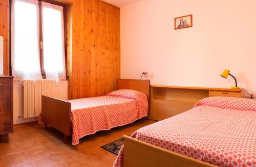 a room with two beds and a chair in it at Maurice des Alpes in Teglio