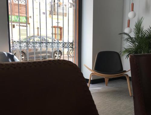 a room with a chair and a window with a car outside at MD Design Hotel - Portal del Real in Valencia