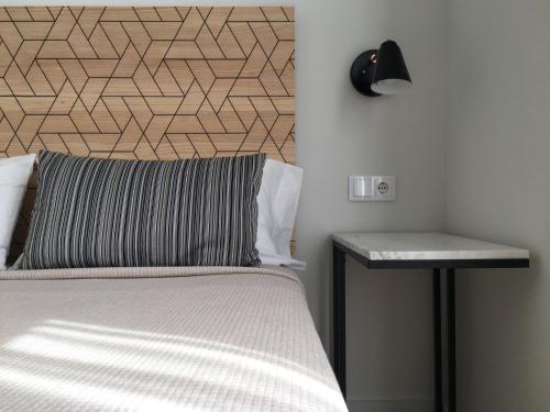 a bedroom with a bed with a lamp and a side table at MD Design Hotel - Portal del Real in Valencia