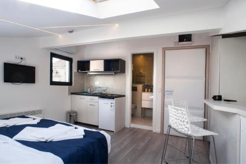 een kleine slaapkamer met een bed en een keuken bij Apartments Villa Savamala in Belgrado