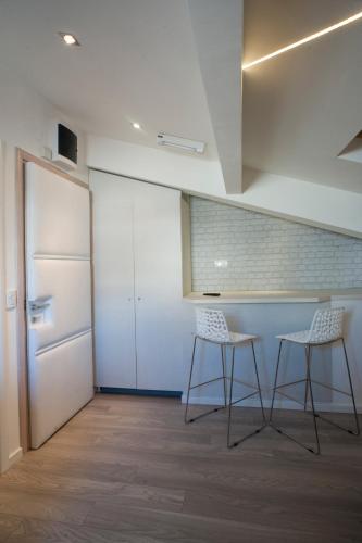 a kitchen with two chairs and a table and a refrigerator at Apartments Villa Savamala in Belgrade