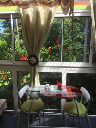 a table and two chairs in front of a window at Pinpin D'amour in Basse Vallée