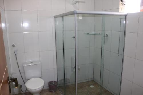 a bathroom with a toilet and a glass shower at Pousada Sol Nascente in Piranhas