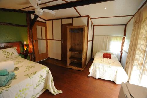 a bedroom with two beds and a door in it at Pousada Abayomi in Paraty