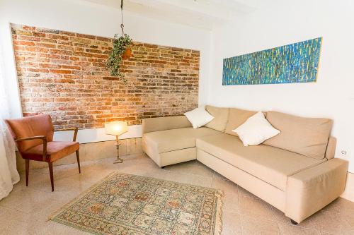 a living room with a couch and a brick wall at Cà Biennale in Venice