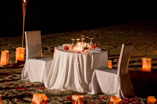 a table and two chairs with a white table and chairsearcher at Vichayito Bungalows & Carpas by Aranwa Hotels in Vichayito