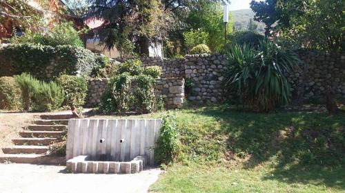 a stone wall with a wooden gate in a yard at Vila Popovski in Ljubaništa