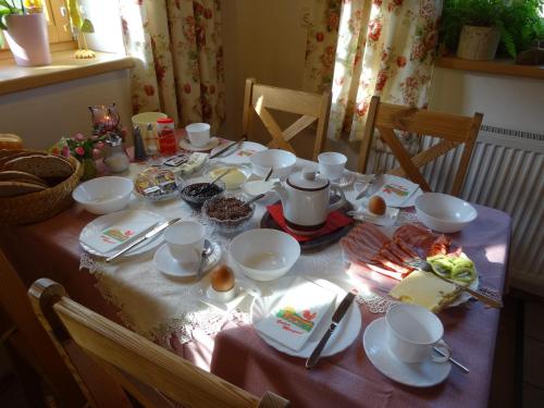 a table with plates and cups and food on it at Badhaus in Achenkirch