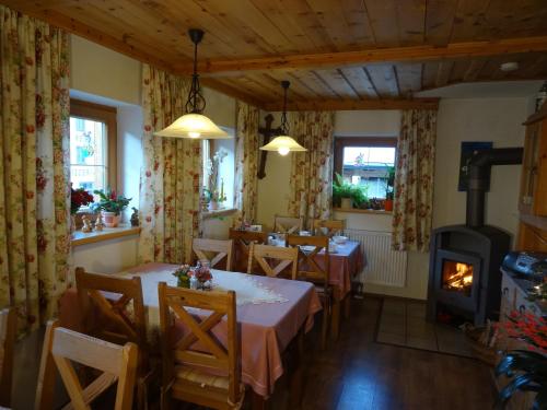 a dining room with tables and a wood stove at Badhaus in Achenkirch