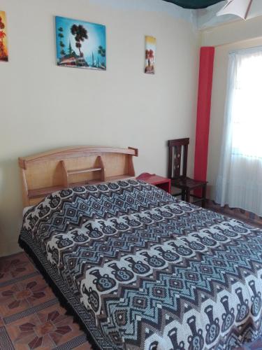 a bedroom with a bed with a black and white comforter at Hostal Puerto Alegre in Copacabana