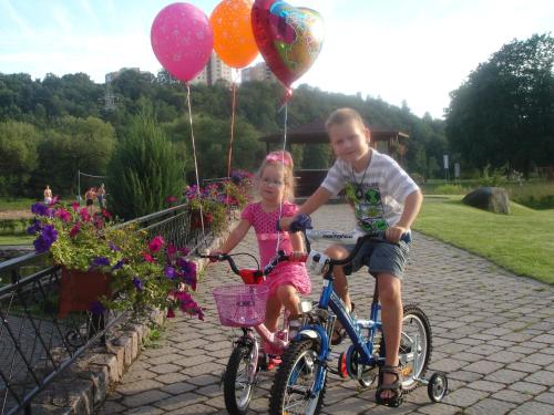 a man and a little girl riding bikes with balloons at Park Villa Hotel in Vilnius