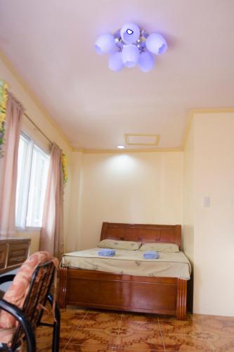 una camera da letto con un letto e un ventilatore a soffitto di Julz Tropical Apartments a Olongapo