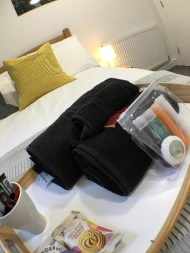 a bed with a pile of black towels on it at Parsons Street in Dudley