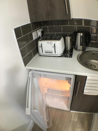 an open refrigerator with a toaster and a sink at Parsons Street in Dudley