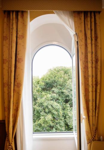 an open window in a room with a tree at Hotel Due Palme in Mergozzo