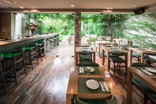 a restaurant with wooden tables and chairs and a bar at Home Hotel in Buenos Aires