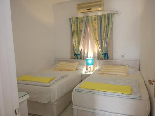 two beds in a small room with a window at Chalet Stella Seaview Resort-Family Only in Ain Sokhna