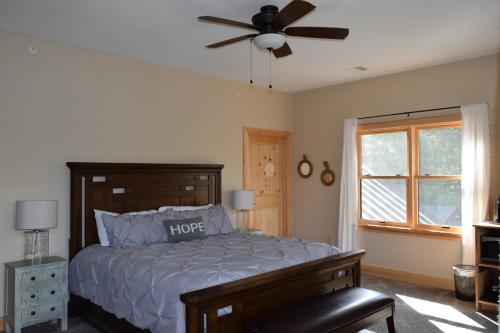 1 dormitorio con 1 cama y ventilador de techo en The Retreat At Norwich Lake, en Huntington