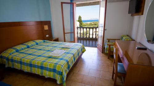 a hotel room with a bed and a balcony at Hotel Navarone in Petrochori