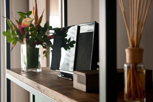 a desk with a computer monitor and a vase of flowers at E&O Residences Kuala Lumpur in Kuala Lumpur