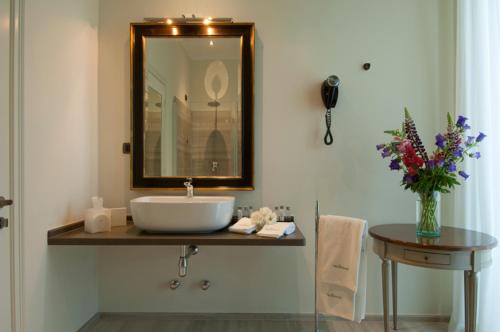 a bathroom with a sink and a mirror and a table at Villa Necchi alla Portalupa in Gambolò