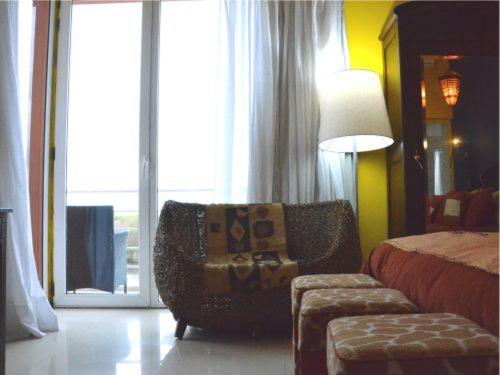 a bedroom with a bed and a chair and a window at Los Muelles Boutique Hotel in Carmelo