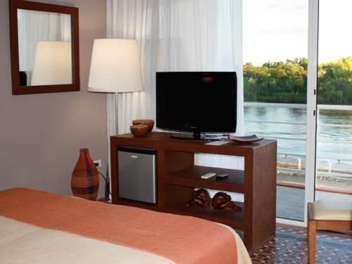a hotel room with a bed and a flat screen tv at Los Muelles Boutique Hotel in Carmelo