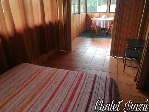 a room with a table and a bed in a room at Hotel Chalets Los Volcanes in Alajuela City