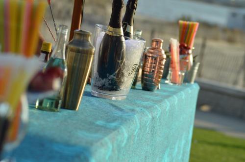 a blue table with many different glass bottles on it at Hôtel Café Miramar in Le Grau-du-Roi