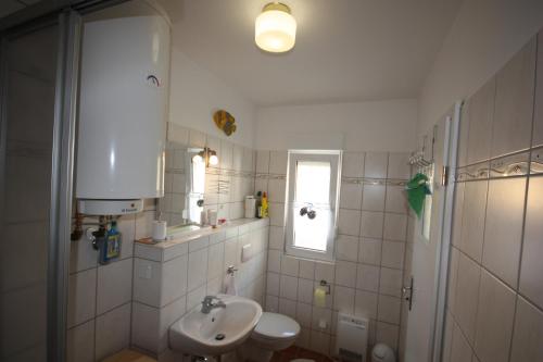a white bathroom with a sink and a toilet at Ferienpark An der Seebrücke in Ostseebad Koserow
