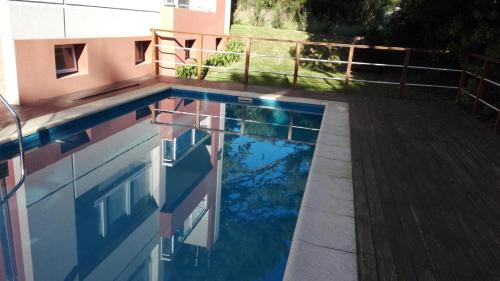 a swimming pool with the reflection of a building at Besugo in Pinamar