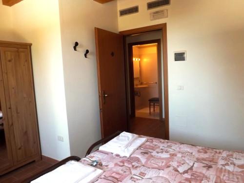 a bedroom with a bed and a door to a bathroom at Tenuta Villa Colle Sereno in Montemarciano