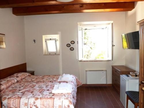 a bedroom with a bed and a window at Tenuta Villa Colle Sereno in Montemarciano