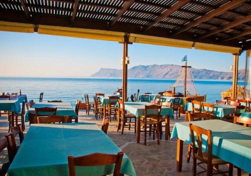 a group of tables and chairs with a view of the ocean at Akrogiali in Kissamos