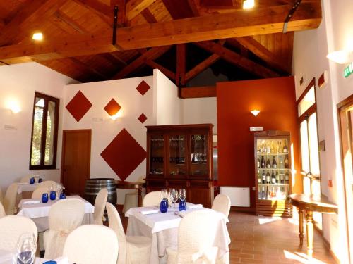 a dining room with white tables and white chairs at Tenuta Villa Colle Sereno in Montemarciano