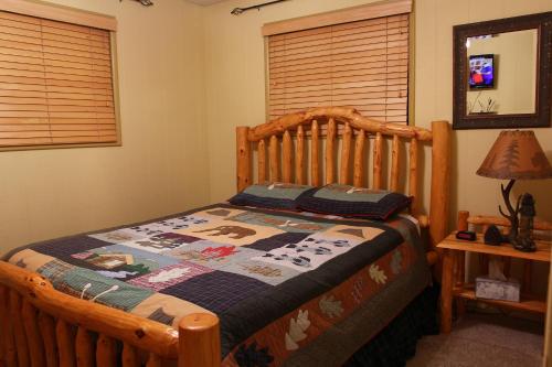 een slaapkamer met een houten bed met een quilt bij Adair Springs Cabin in Pinetop-Lakeside