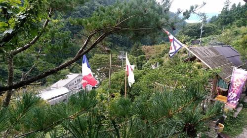 a group of flags on a hill with a train at Experiencing Traditional Life Style Inn Kajiya Iya Romantei in Miyoshi