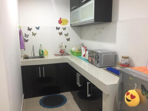 eine kleine Küche mit einer Theke und einer Mikrowelle in der Unterkunft Apartment Wakaf Che yeh in Kota Bharu