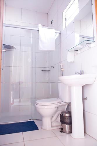 a white bathroom with a toilet and a sink at Bellonorte Hotel in Altamira