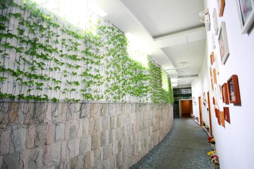 a hallway with a wall covered in plants at Landscape Fashion Hotel Guangzhou East Station in Guangzhou