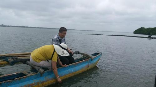 two men in a small boat in the water at Marine Hostel at Negombo Beach Near Airport in Negombo