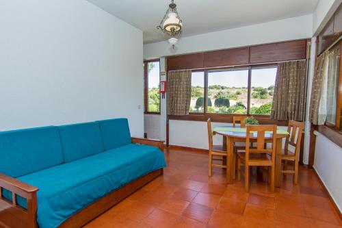 a living room with a blue couch and a table at Torralta Apartment in Alvor