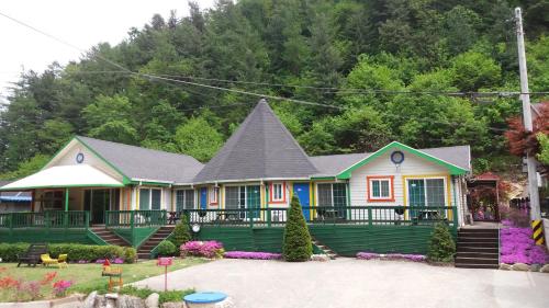 a large house with a gambrel roof at Charm Pension in Gapyeong