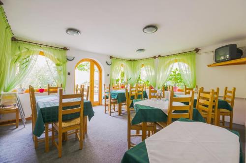 a restaurant with tables and chairs with green tablecloths at Babi Guesthouse - Babi Vendégház in Balatonfüred