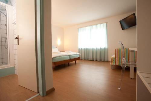 a small room with a bed and a window at Ristorante Groven in Lostallo