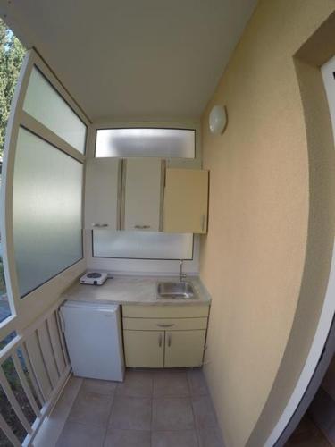 a small kitchen with a sink and a refrigerator at Apartmani Tona in Gradac