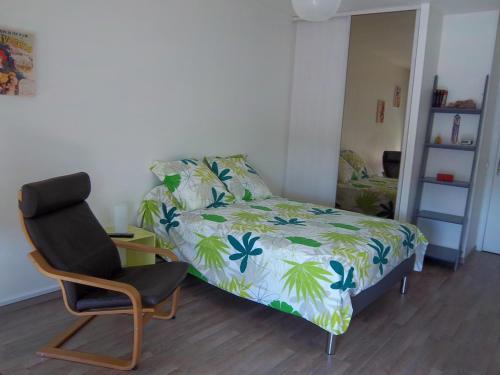 een kleine slaapkamer met een bed en een stoel bij Résidence les Peupliers in Chamalières
